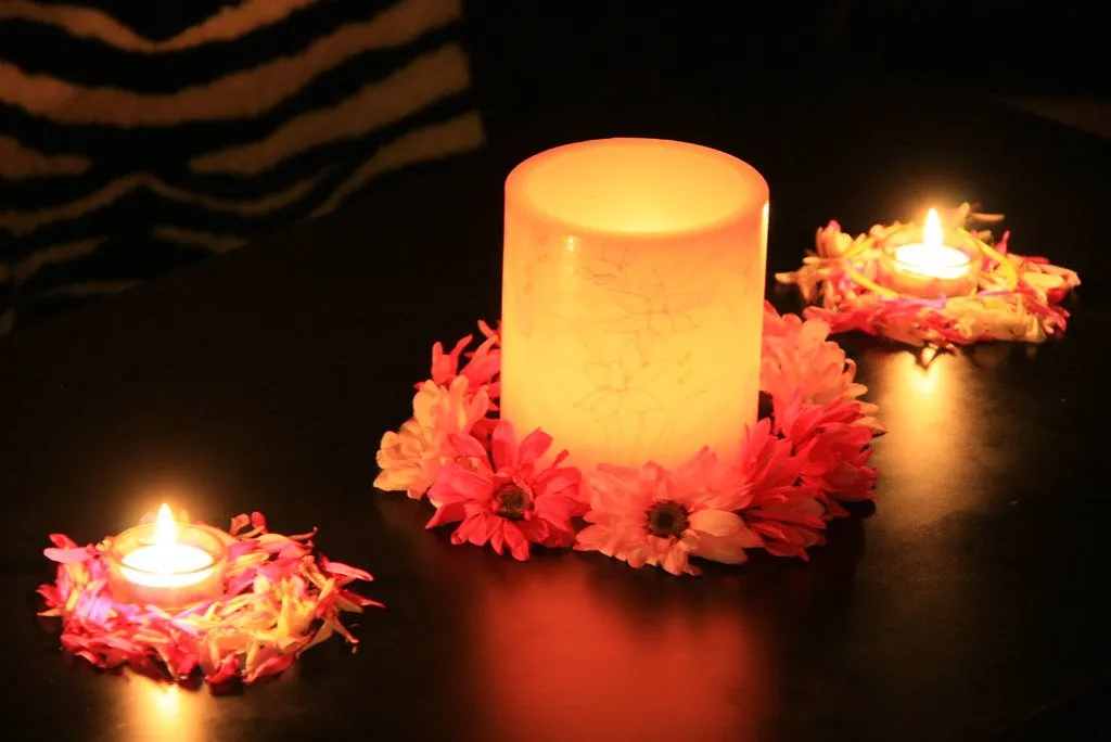 Flower petals and tealights glowing on a dark table