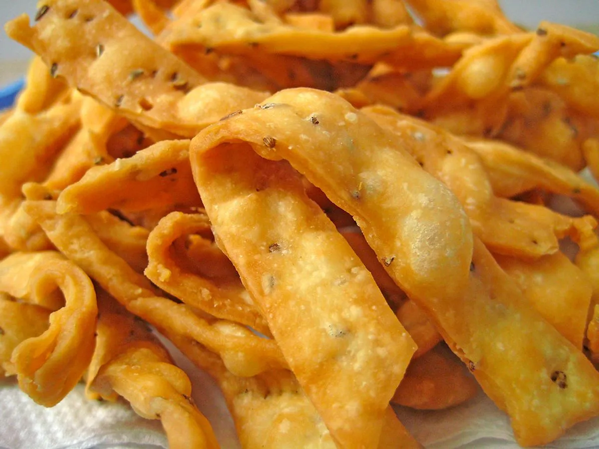 Crisp golden namak pare strips with ajwain seeds