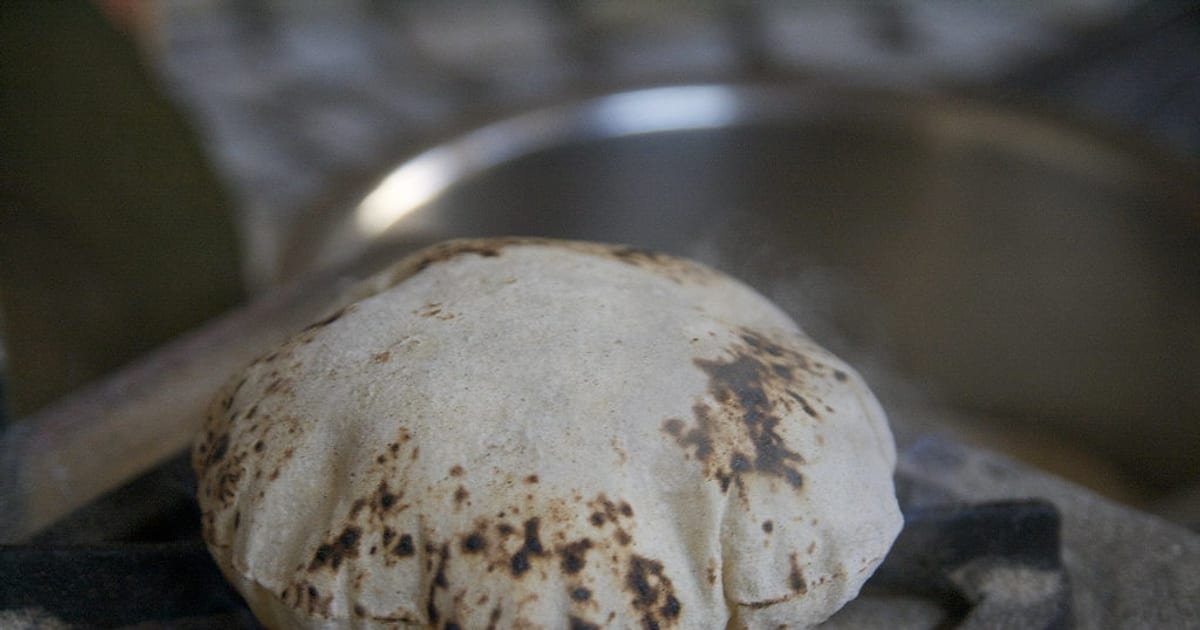 A phulka roti puffed up round over the flame, just off the tawa