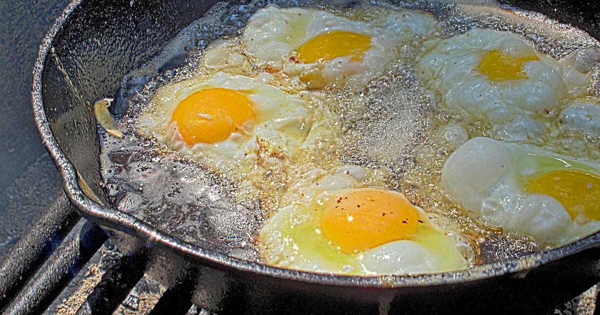 Eggs sizzling in a cast iron pan — they fry and slide without any non-stick coating