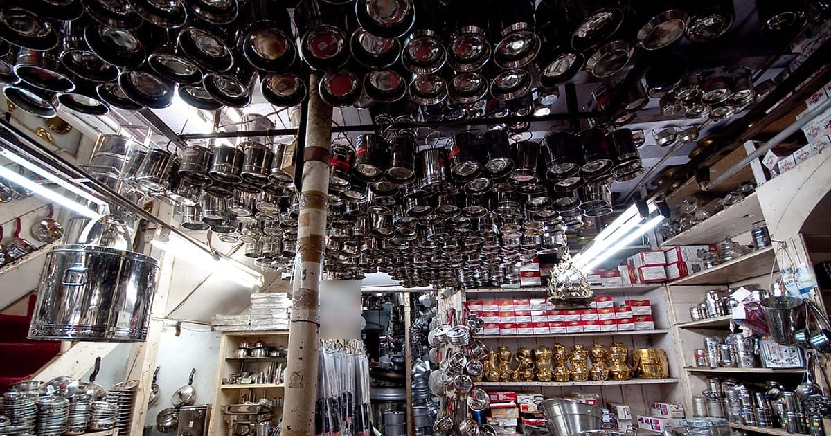 The ceiling of an Indian utensil shop hung with hundreds of shining stainless steel pots and tumblers