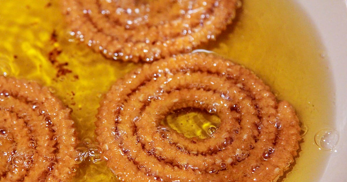 Chakli spirals turning golden as they fry in hot oil for Diwali